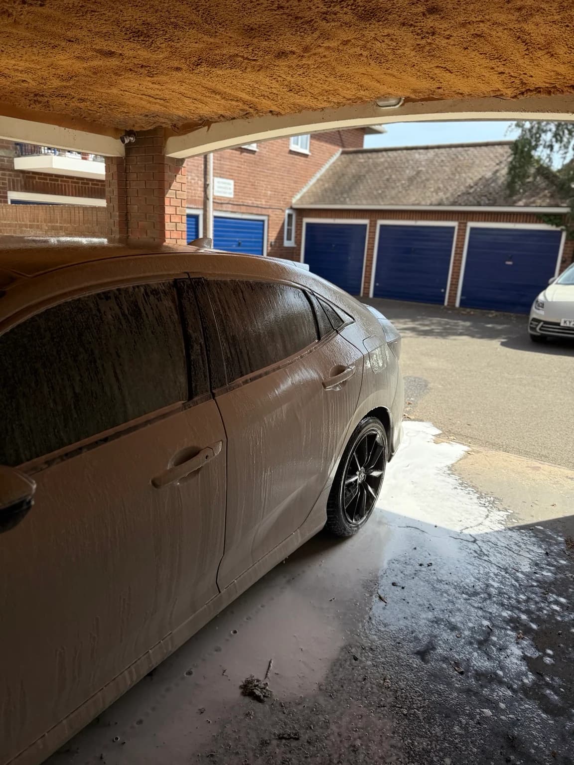 Honda Civic covered in snow foam during exterior preparation
